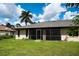 Back of house with screened porch and yard at 1565 Dorchester St, Port Charlotte, FL 33952