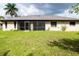 Rear view of house with grassy backyard at 1565 Dorchester St, Port Charlotte, FL 33952