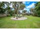 Spacious backyard with fire pit and seating area, surrounded by lush landscaping at 182 Monica St, Port Charlotte, FL 33954