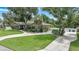 One-story house with a large yard, driveway, and mature trees at 182 Monica St, Port Charlotte, FL 33954