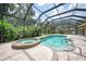 Inviting pool area with spa, screened enclosure, and flagstone patio at 182 Monica St, Port Charlotte, FL 33954