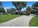 One story house with a large yard, palm trees, and a long driveway at 182 Monica St, Port Charlotte, FL 33954