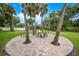 Relaxing backyard patio with fire pit, surrounded by lush landscaping and palm trees at 182 Monica St, Port Charlotte, FL 33954
