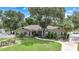 One-story house with a large yard, driveway and mature trees at 182 Monica St, Port Charlotte, FL 33954