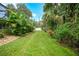Long backyard with lush landscaping and a fence at 182 Monica St, Port Charlotte, FL 33954