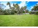 Large grassy backyard with circular patio and palm trees at 182 Monica St, Port Charlotte, FL 33954