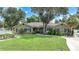 One-story house with a brown exterior, manicured lawn, and a paved driveway at 182 Monica St, Port Charlotte, FL 33954