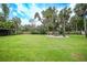 Large grassy backyard with circular patio and lush landscaping at 182 Monica St, Port Charlotte, FL 33954