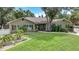 One-story house with a brown exterior, manicured lawn, and a paved driveway at 182 Monica St, Port Charlotte, FL 33954