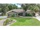 One-story house with a brown exterior, manicured lawn, and a paved driveway at 182 Monica St, Port Charlotte, FL 33954