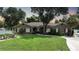 One-story house with a brown exterior, manicured lawn, and a paved driveway at 182 Monica St, Port Charlotte, FL 33954