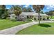 Single-story home with light-colored facade, palm trees, and a well-manicured lawn at 4041 Michel Tree St, Port Charlotte, FL 33948