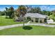 Single-story home with light-colored facade, palm trees, and a well-manicured lawn at 4041 Michel Tree St, Port Charlotte, FL 33948