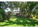 Landscaped backyard, featuring tropical plants and a large oak tree at 4041 Michel Tree St, Port Charlotte, FL 33948