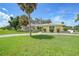 House exterior showcasing a spacious lawn and palm trees at 4041 Michel Tree St, Port Charlotte, FL 33948