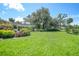Spacious backyard with lush lawn, mature trees, and landscaping at 4041 Michel Tree St, Port Charlotte, FL 33948