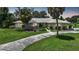 Single-story home with a tiled roof, palm trees, and a landscaped lawn at 4041 Michel Tree St, Port Charlotte, FL 33948