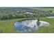 Aerial view of a pond on a property with lush greenery at 15300 Water Oak Ct, Punta Gorda, FL 33982