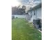 Backyard with grassy area, AC unit, and water softener at 2106 Switzerland Rd, North Port, FL 34288