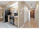 Kitchen with black appliances and entry hallway with tile floors at 791 Haleybury St, Port Charlotte, FL 33948