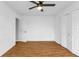 Bright bedroom featuring wood-look floors, ceiling fan, and ample closet space at 791 Haleybury St, Port Charlotte, FL 33948