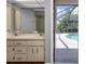 Bathroom boasts double sinks and a view of the pool through a screened enclosure at 791 Haleybury St, Port Charlotte, FL 33948