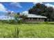 Brick home with damaged roof and boarded windows, situated on a grassy lot at 31840 Washington Loop Rd, Punta Gorda, FL 33982