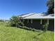 Damaged roofline of brick building with overgrown landscaping at 31840 Washington Loop Rd, Punta Gorda, FL 33982