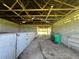 Barn interior with dirt floor, multiple stalls, and exposed beams at 31840 Washington Loop Rd, Punta Gorda, FL 33982