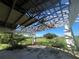 Open carport with damaged roof and overgrown landscaping at 31840 Washington Loop Rd, Punta Gorda, FL 33982