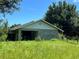 Block building with a single garage door in a grassy field at 31840 Washington Loop Rd, Punta Gorda, FL 33982