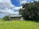 Brick building with damaged roof and overgrown landscaping at 31840 Washington Loop Rd, Punta Gorda, FL 33982