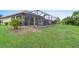 Spacious backyard with grassy area and screened pool at 1596 Hyssop Loop, North Port, FL 34289