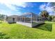 A lush, green backyard with a screened-in pool, offering a private and serene outdoor space at 3159 Draper Ter, North Port, FL 34286