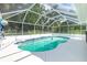 Screened-in pool with clear water and tile accents surrounded by a bright white deck and lush greenery at 3159 Draper Ter, North Port, FL 34286