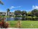 Tranquil pond view with lush landscaping and palm trees at 1250 W Marion Ave # 242, Punta Gorda, FL 33950