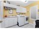Laundry room with washer, dryer, and storage cabinets at 1250 W Marion Ave # 242, Punta Gorda, FL 33950