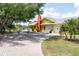 Bright yellow house with a large driveway, brick pavers, and a view of a canal at 24395 Suncoast Blvd, Punta Gorda, FL 33980