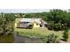 Aerial view of a yellow house near a pond with lush greenery at 24395 Suncoast Blvd, Punta Gorda, FL 33980