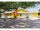 Bright yellow house with a large driveway and mature trees at 24395 Suncoast Blvd, Punta Gorda, FL 33980