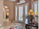 Bright entryway with tiled floors, console table, and view to the bedroom at 24588 Buckingham Way, Port Charlotte, FL 33980