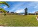 Spacious backyard with lush lawn, pond, and mature trees at 24588 Buckingham Way, Port Charlotte, FL 33980