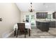Kitchen and dining area with dark gray cabinets, granite counters, and wood-look floors at 3159 Draper Ter, North Port, FL 34286
