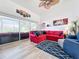 Relaxing living room with red sectional sofa, wood floors, and access to the patio at 6568 Fairway Gardens Dr, Bradenton, FL 34203