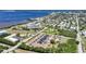 Aerial view of condos with a parking lot, landscape, and a pool, with a waterfront in the background at 1001 W Marion Ave # 14, Punta Gorda, FL 33950