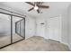 Bright bedroom features a ceiling fan, tile flooring, neutral paint, and closet storage at 1001 W Marion Ave # 14, Punta Gorda, FL 33950
