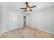 Spacious bedroom with ceiling fan, tile flooring, neutral paint, and closet storage at 1001 W Marion Ave # 14, Punta Gorda, FL 33950