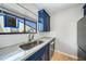 Modern kitchen featuring stainless steel appliances, granite countertops, and custom blue cabinetry at 1001 W Marion Ave # 14, Punta Gorda, FL 33950