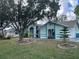 Single-story home with a teal exterior, screened entryway, and attached garage at 269 Rosemary St, Port Charlotte, FL 33954