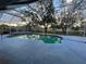 This pool features a large screened-in area with lush green foliage in the background at 269 Rosemary St, Port Charlotte, FL 33954